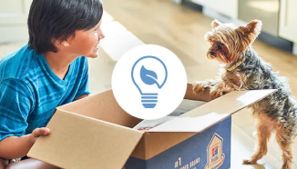A young boy and a dog looking at recyclable Hill’s box with a reducing waste icon on it